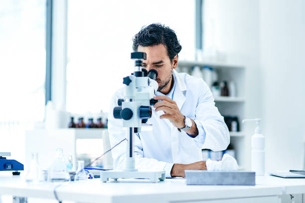 Today is all about uncovering something new Shot of a young scientist using a microscope in a lab science research stock pictures, royalty-free photos & images