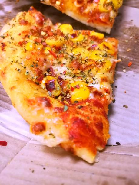 Piece of cheese and corn pizza with bell pepper.