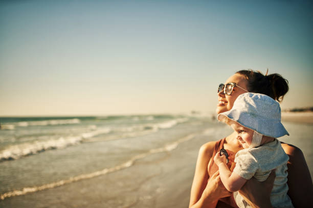 Shot of a young woman enjoying a day at the beach with her adorable baby girl