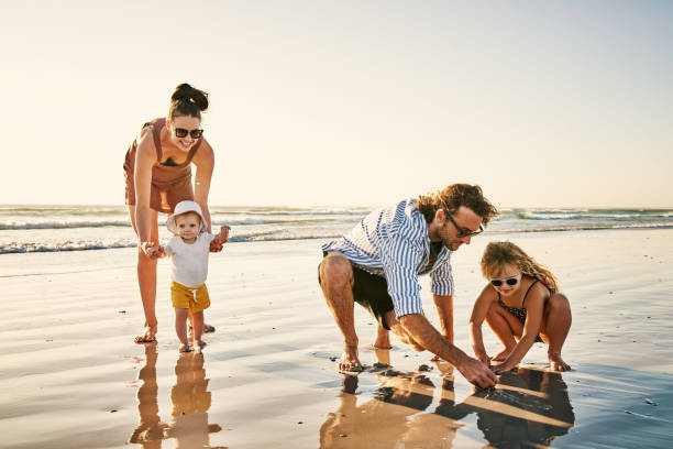 The more time we give the more we get back Shot of a happy young family enjoying a day at the beach family vacation stock pictures, royalty-free photos & images