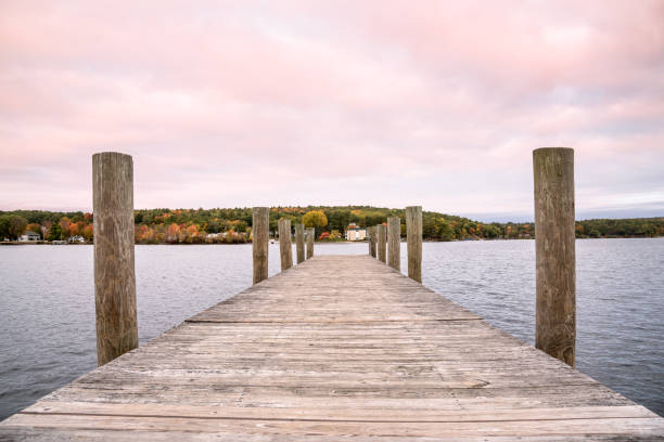 Deserted jetty on a lake under a colourful sky at dusk