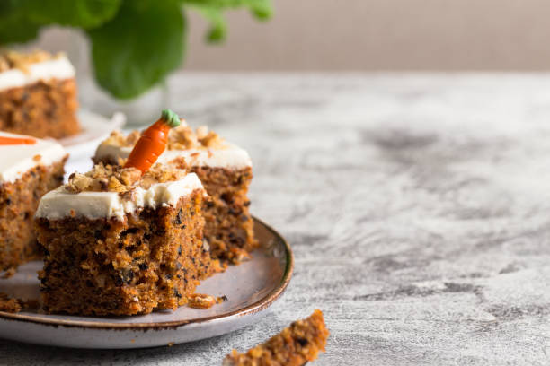 istock pieces of carrot cake with walnuts with icing cream on a light background. tinting. selective focus 1227556340