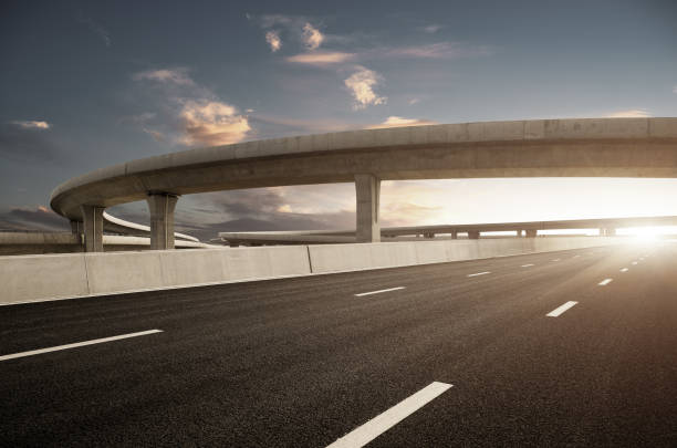 Dusk colored clouds in the background, highway overpass curved approach bridge