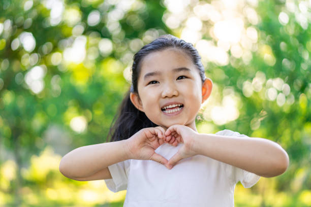 istock Little Girl Making Heart Shaped Gesture 1227558276