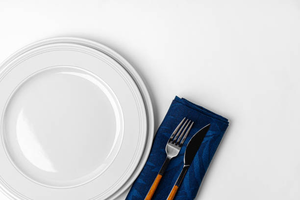 istock Fork, knife and plate on towel. Isolated on white background. 1227559000