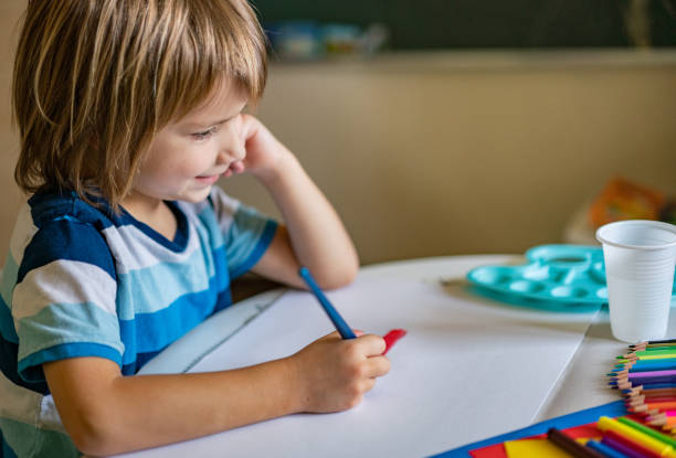 istock Happy boy is using watercolors to paint at home 1227561282