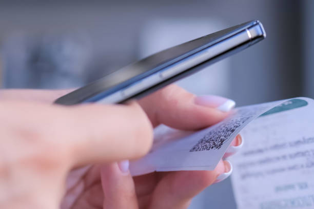 istock Closeup: woman using smartphone and scanning qr code on cash shop receipt paper 1227561291