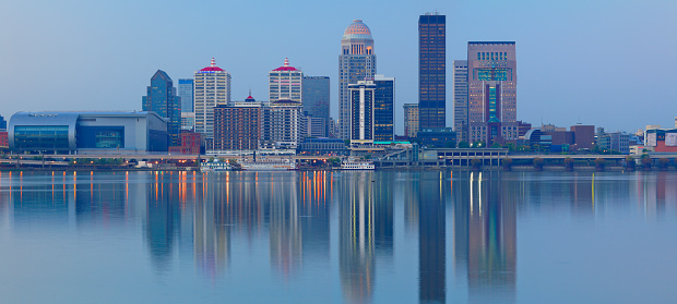 Panoramic view of the skyline of Louisville - the largest city in the commonwealth of Kentucky - as seen at dawn from across the Ohio river.