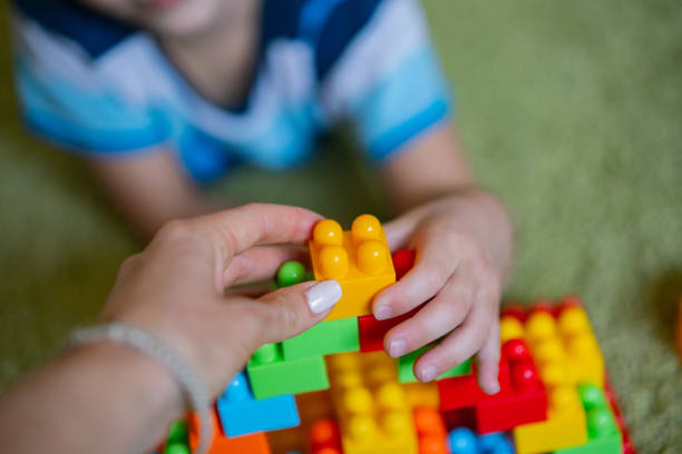 istock Close-up human hands holds plastic toy block 1227561384