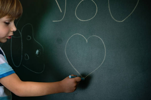 istock Little child is drawing on chalkboard in home quarantine 1227562658