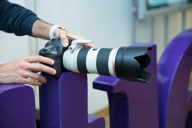 カメラマンはカメラ・カノンef 70-200mm f 2.8l usmレンズを持っています。カノン70-200 lレンズをクローズアップ. - camera dslr canon lens ストックフォトと画像