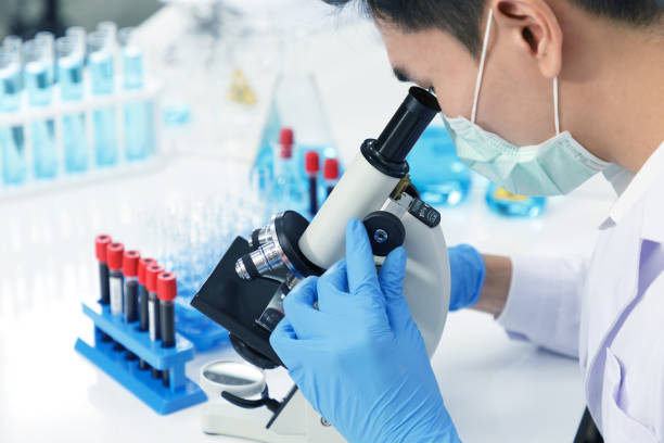 istock Asian Male Scientist using Microscope working in Lab while Checking Result of Blood Sample testing. 1227562784