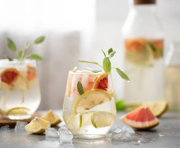 Lemonade made from lemon, lime, grapefruit and mint. Lemon, lemon, lime, grapefruit and mint lemonade in a glass goblet on the table infused water stock pictures, royalty-free photos & images