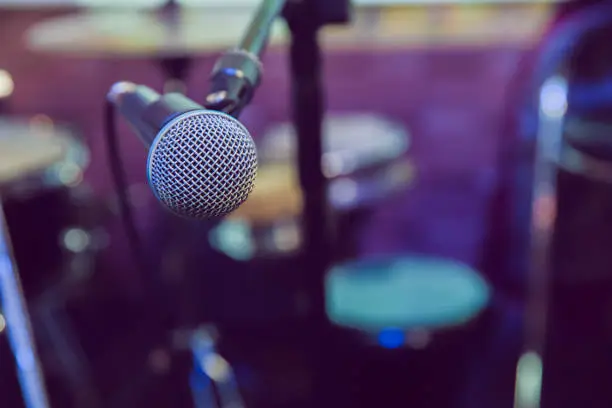 Photo of Musical Concept. recording, selective focus microphone in radio studio, selective focus microphone and blur musical equipment guitar,bass,drum piano