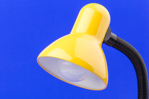 istock Yellow desk lamp isolated on blue  background 1227565491