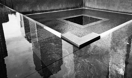 New York City, USA - October 16, 2016: Building reflections in the water of the 9/11 Memorial Site