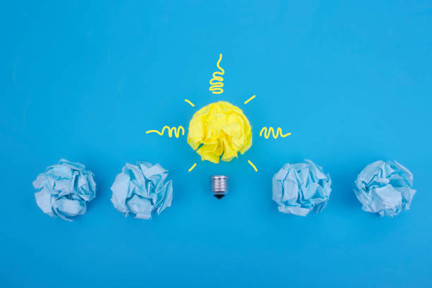 istock Idea of solution. Concept Lamp with crumpled paper on a blue background, be different. 1227568377
