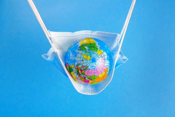 Earth globe in medicine mask to fight against Corona virus stock photo