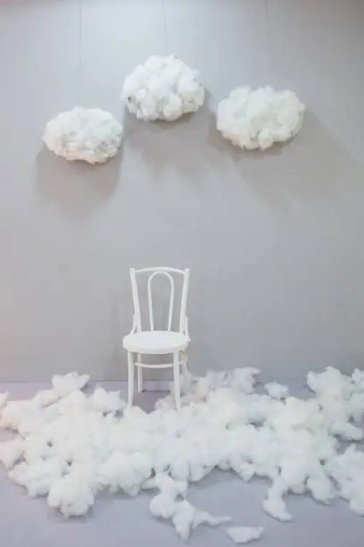 White wall white chair white floor. Cotton snow and cotton clouds in the sky. Cotton ball as a wool and earsticks . Studio background