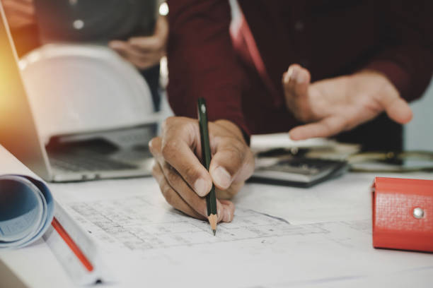 istock hands of group engineer and architect working on blueprint and laptop computer on workplace desk in meeting room project at construction site office, contractor, engineering and construction concept 1227570939