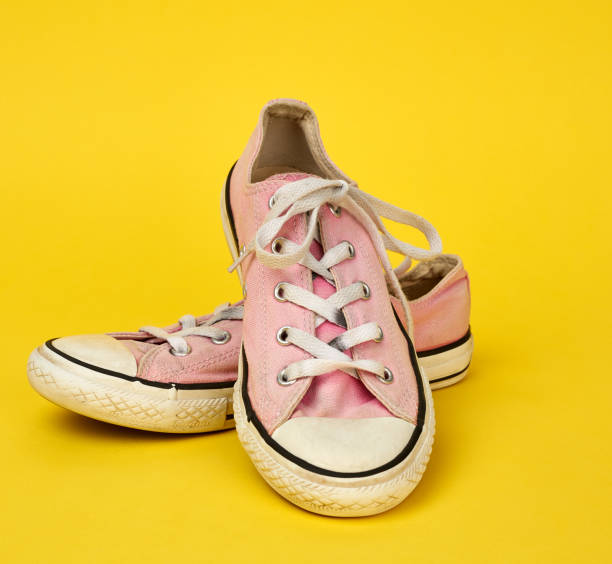 istock pair of pink very worn textile sneakers with rubber soles 1227573295