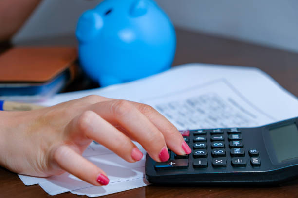 istock Financial data analyzing hand writing and counting on calculator at home on wooden desk,Business and finance concept. 1227574551