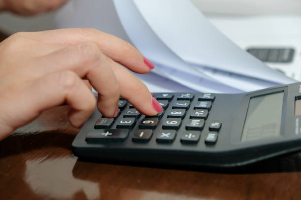 istock Financial data analyzing hand writing and counting on calculator at home on wooden desk,Business and finance concept. 1227575128