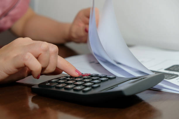 istock Financial data analyzing hand writing and counting on calculator at home on wooden desk,Business and finance concept. 1227575159