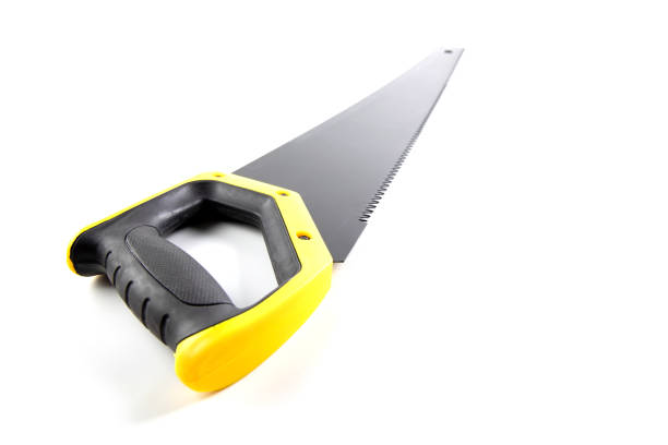 Selective Focus at handle of hand saw with matte black saw blade and yellow plastic handle and covered with black rubber to tighten the hand.