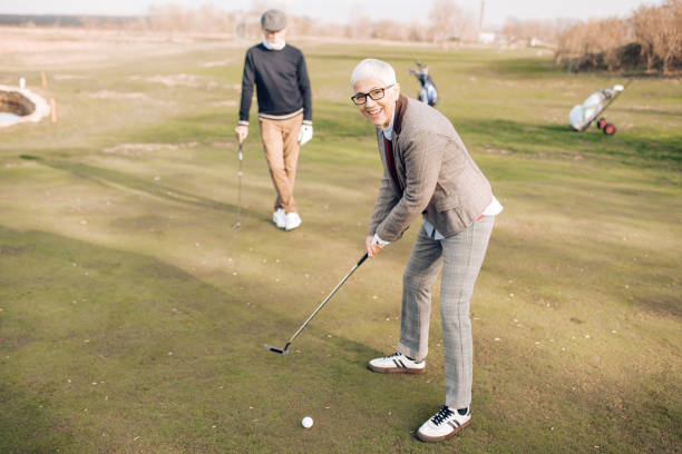 istock Mature woman taking a golf shot 1227575415