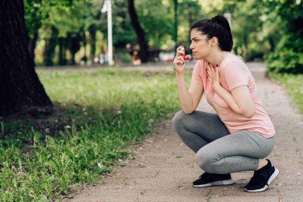 Girl using asthma inhaler during jogging Girl using asthma inhaler during jogging in the park. Asthma stock pictures, royalty-free photos & images