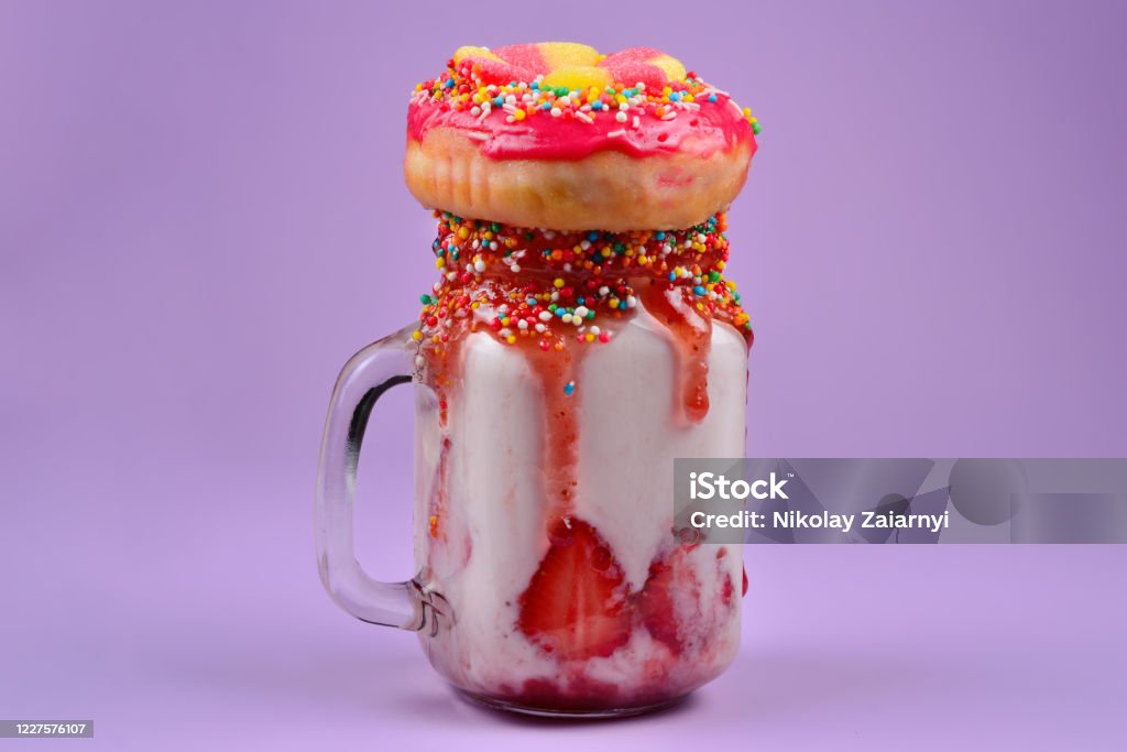 Freakshake. Extreme milkshake met aardbei, gelei snoep, donut. - Royalty-free Bizar Stockfoto