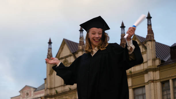 istock Happy graduate student holding a diploma smiling to camera 1227578722