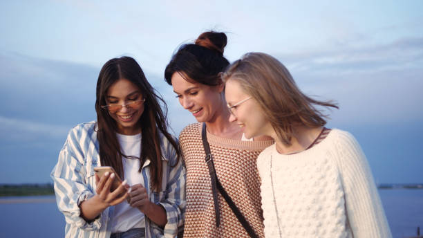 istock Female Friends Looking At Smart Phone Screen and Laughing 1227578864