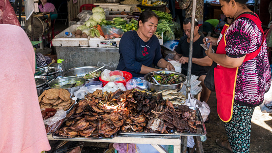 Food and drink is commonly offered for sale by mobile vendors on the streets of Phnom Penh, Cambodia. In Cambodia, the number of street vendors increases during periods of economic boom and crises and around 80 percent of GDP and 95 percent of employment is said to come from the “informal” sector which is heavily dominated by women who work up to 13 hours a day to keep food on the table for themselves and their families.