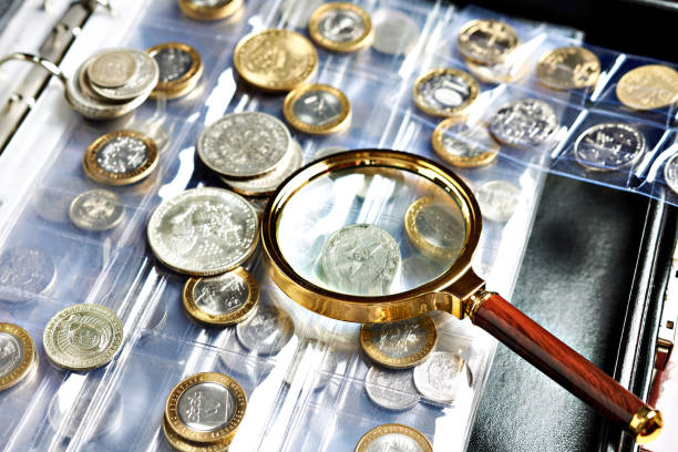 Numismatic coins with magnifying glass Collecting coins numismatics. Album with magnifying glass coin collection stock pictures, royalty-free photos & images