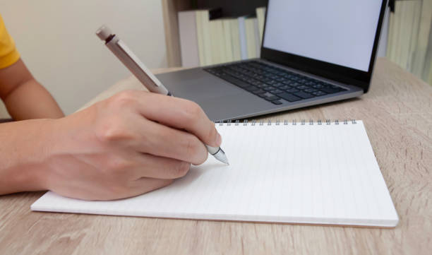 istock Closeup of hand writing on paper 1227579040