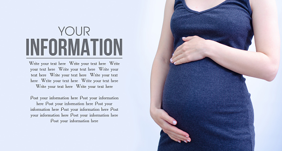 Pregnant woman belly on gray background, space for text