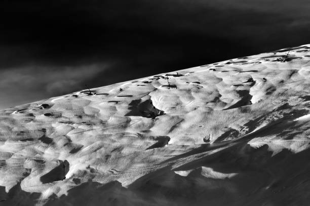 Off-piste snowy slope at windy winter night