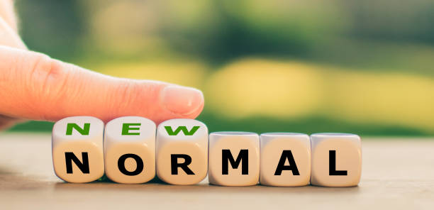 istock New normal concept. Hand turns dice and changes the expression 