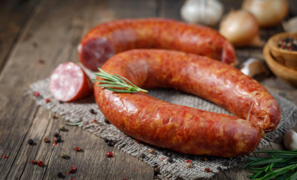 wędzona kiełbasa na drewnianym stole. - wędzona kiełbasa zdjęcia i obrazy z banku zdjęć