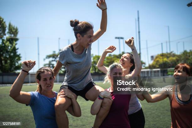Excited Teammates Celebrating The Victory After Soccer Match Stock Photo - Download Image Now