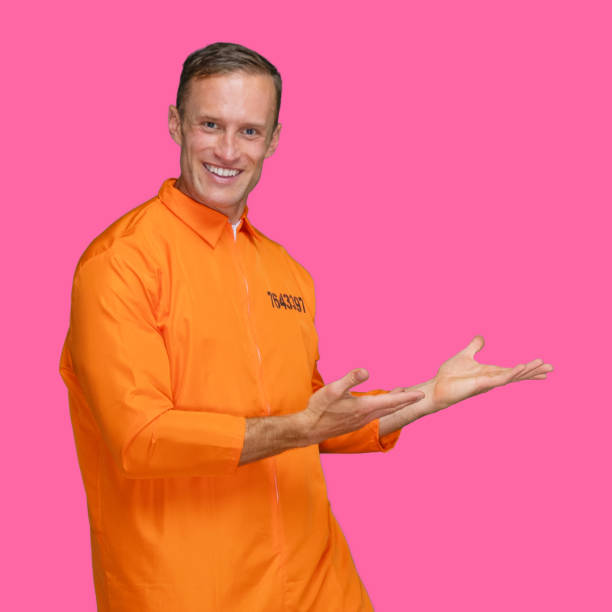 istock Criminal standing in front of colored background wearing jumpsuit 1227588328