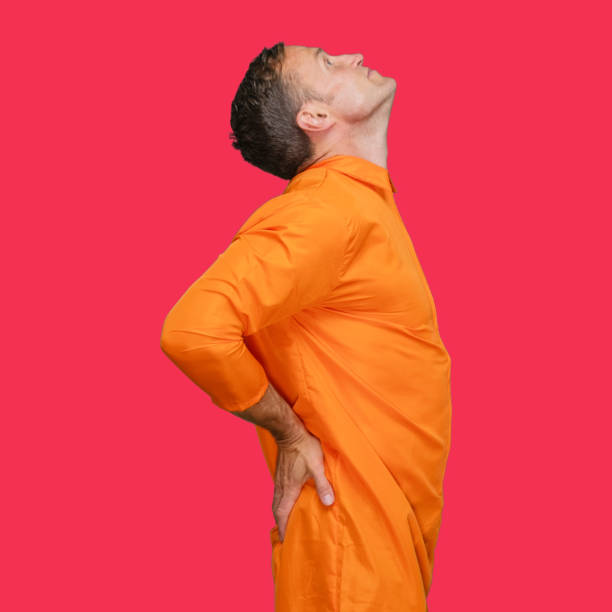 istock Criminal standing in front of colored background wearing jumpsuit 1227588342