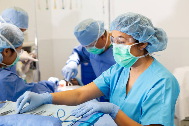 asistente quirúrgica trabaja en quirófano - hair net nurse scrubs asian ethnicity fotografías e imágenes de stock