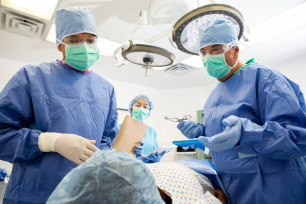 dos cirujanos hablan con el paciente antes de la cirugía - hair net nurse scrubs asian ethnicity fotografías e imágenes de stock