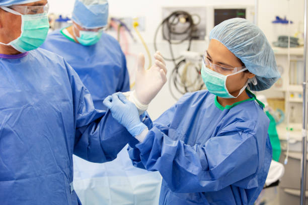 los cirujanos se preparan para operar - hair net nurse scrubs asian ethnicity fotografías e imágenes de stock