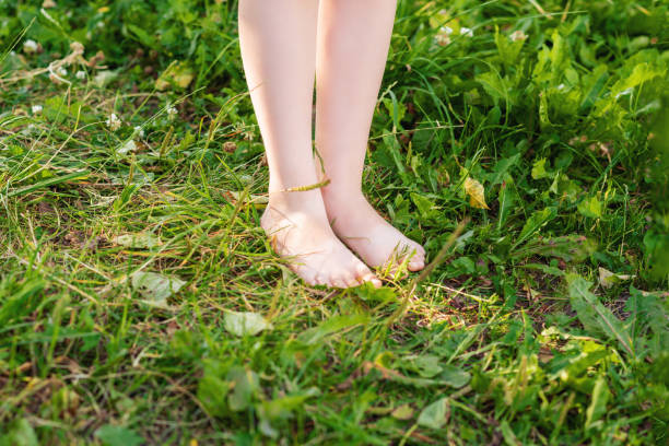 istock Barefoot of child standing on green grass. 1227588463