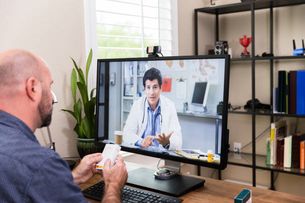 istock Man uses desktop computer to video conference with doctor 1227588588