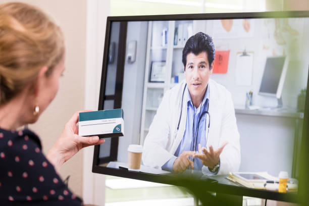 istock Unrecognizable woman holding medicine asks doctor questions via computer 1227588593